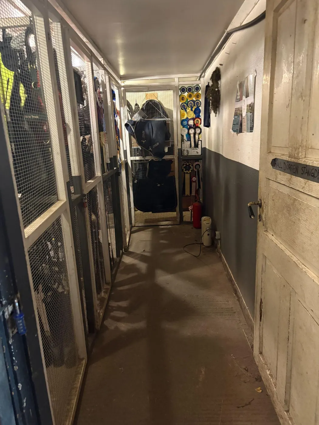 Stallgång med boxar och upphängd utrustning